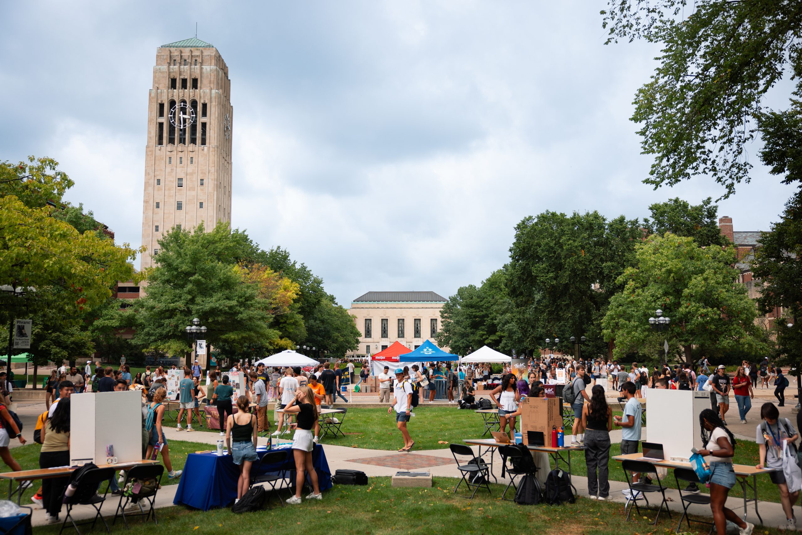 Students walk between tables and into tents set up on University Avenue during Festifall 2024.